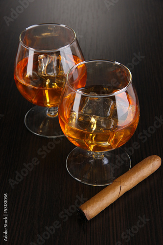 Photo: Brandy glasses with ice on wooden background Brandy glasses with ice on wooden background
