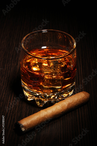 Photo: Brandy glass with ice on wooden background Brandy glass with ice on wooden background