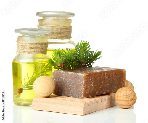Photo: Hand-made soap and bottles of fir tree oil, isolated on white Hand-made soap and bottles of fir tree oil, isolated on white