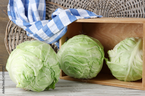Photo: Cabbage on table on wooden background Cabbage on table on wooden background