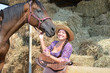 Girl and her horse resting near a haystack