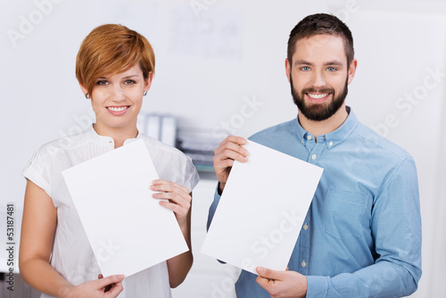 Photo: zwei auszubildende im büro zeigen weiße schilder zwei auszubildende im büro zeigen weiße schilder