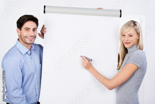 Photo: kollegen im büro stehen vor weißem flipchart kollegen im büro stehen vor weißem flipchart