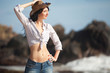 Fashion woman with cowboy hat on the beach
