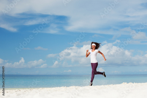 Photo: Young woman running on the beach Young woman running on the beach