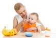 mother spoon feeding baby boy