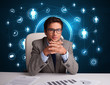 Photo: Businessman sitting at desk with social network icons Businessman sitting at desk with social network icons