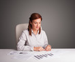 Photo: Businesswoman sitting at desk and doing paperwork Businesswoman sitting at desk and doing paperwork