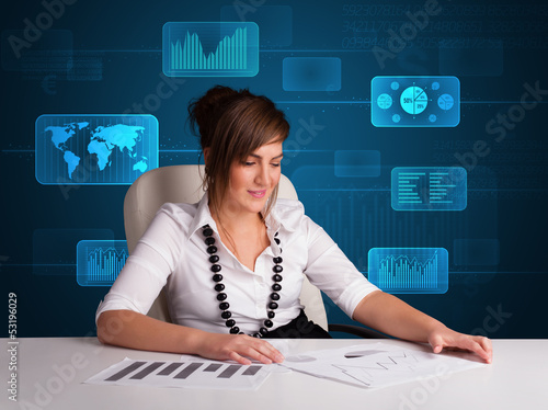 Photo: Businesswoman doing paperwork with digital background Businesswoman doing paperwork with digital background