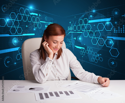 Photo: Businesswoman doing paperwork with futuristic background Businesswoman doing paperwork with futuristic background