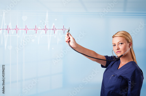Photo: Pretty medical doktor listening to red pulse and heart rates Pretty medical doktor listening to red pulse and heart rates