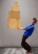 Young man holding a set of brown cardboard boxes