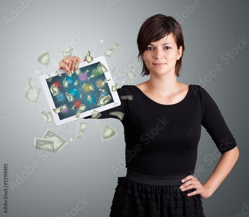 Photo: young woman holding tablet with money young woman holding tablet with money