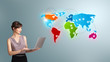 Foto: Young woman holding a laptop and presenting colorful world map Young woman holding a laptop and presenting colorful world map
