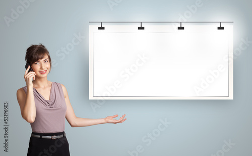 Photo: young woman standing next to a modern copy space and making phon young woman standing next to a modern copy space and making phon