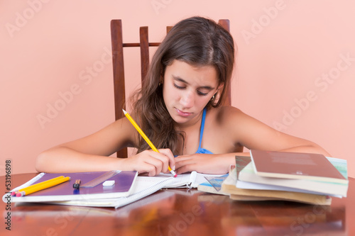 Photo: Hispanic girl working on her school homework Hispanic girl working on her school homework