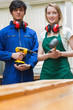 Two woodworking students standing before a workbench