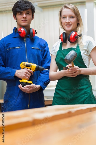 Photo: Two woodworking students standing before a workbench Two woodworking students standing before a workbench