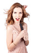 Photo: Beautiful woman singing into a hair styling brush Beautiful woman singing into a hair styling brush