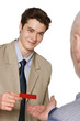 Business man smiling while giving his credit card