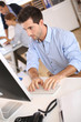 Photo: Man in office working on desktop computer Man in office working on desktop computer