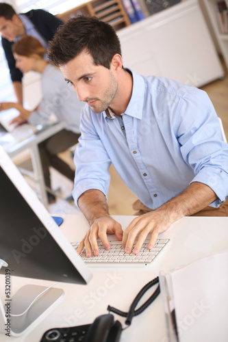 Photo: Man in office working on desktop computer Man in office working on desktop computer