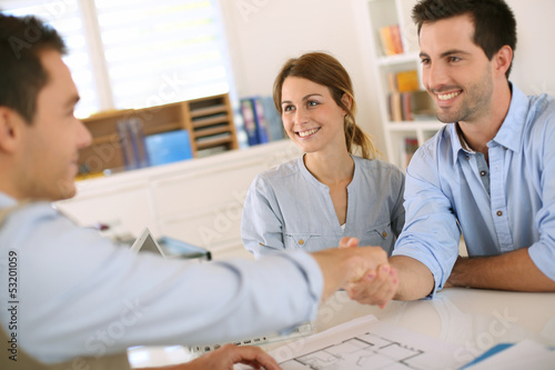 Photo: Young couple meeting construction planner Young couple meeting construction planner