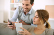 Photo: Young couple using smartphone at home Young couple using smartphone at home