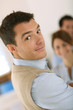 Foto: Handsome man standing in front of business team Handsome man standing in front of business team