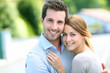 Cheerful couple standing in front of new house
