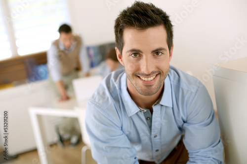 Photo: Smiling successful man standing in office Smiling successful man standing in office
