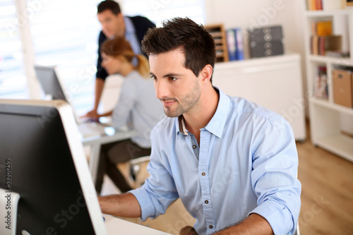 Photo: Man in office working on desktop computer Man in office working on desktop computer