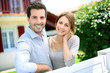 Cheerful couple standing in front of new house