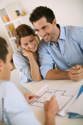 Photo: Young couple meeting architect for future house Young couple meeting architect for future house