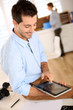 Photo: Trendy guy working in office with tablet Trendy guy working in office with tablet