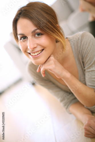 Photo: Smiling girl relaxing on the floor at home Smiling girl relaxing on the floor at home