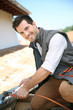 Foto: Roofer working on house roof to fix gutter Roofer working on house roof to fix gutter