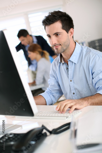 Photo: Man in office working on desktop computer Man in office working on desktop computer