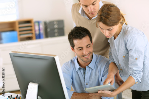 Photo: Office workers using tablet and computer Office workers using tablet and computer