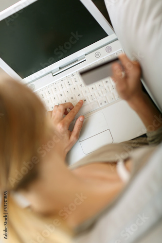 Photo: Back view of woman in sofa shopping on internet Back view of woman in sofa shopping on internet