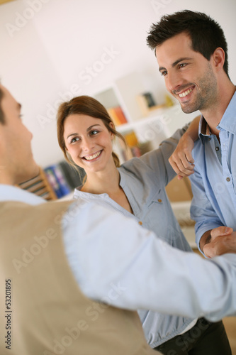Photo: Cheerful couple shaking hand to salesman Cheerful couple shaking hand to salesman