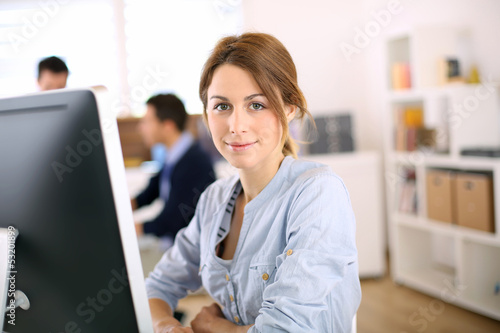 Photo: Portrait of cheerful girl in office Portrait of cheerful girl in office