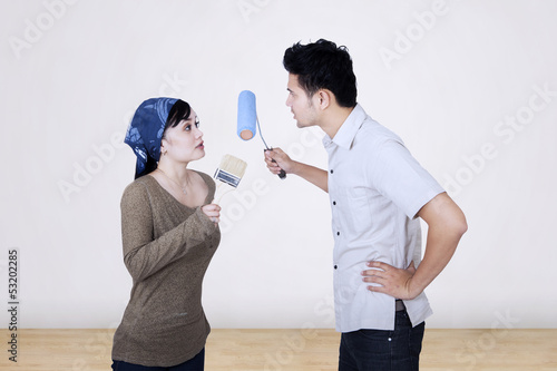 Photo: Asian couple argue while painting Asian couple argue while painting