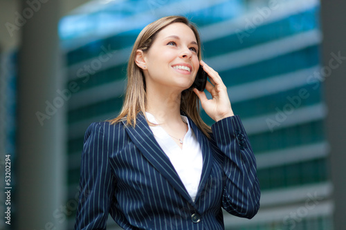 Photo: Businesswoman on the phone in urban setting Businesswoman on the phone in urban setting