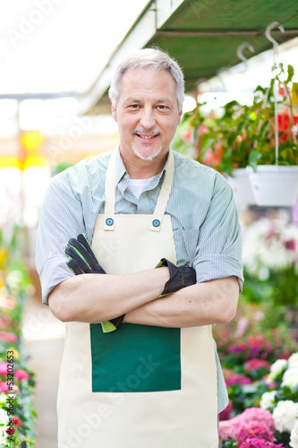 Photo: Mature gardener in a greenhouse Mature gardener in a greenhouse