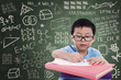 Photo: Boy writing on book in classroom Boy writing on book in classroom