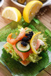antipasto di crostini con salmone, verdure e uova di lompo