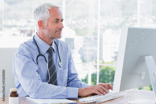 Photo: Doctor typing on his computer Doctor typing on his computer