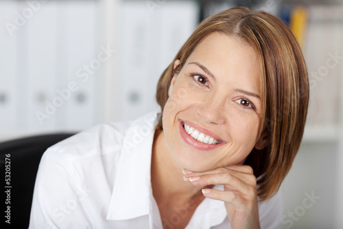 Photo: Portrait of a pretty smiling woman at the office Portrait of a pretty smiling woman at the office