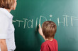 Photo: Young boy writing on the blackboard Young boy writing on the blackboard